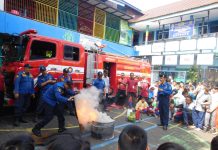 Tim Dinas Pemadam Kebakaran Kota Surabaya saat memberikan contoh memadamkan api di halaman SD Muhammadiyah 15 Surabaya.