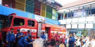 Tim Dinas Pemadam Kebakaran Kota Surabaya saat memberikan contoh memadamkan api di halaman SD Muhammadiyah 15 Surabaya.