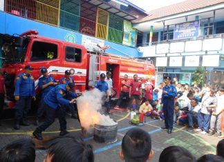 Tim Dinas Pemadam Kebakaran Kota Surabaya saat memberikan contoh memadamkan api di halaman SD Muhammadiyah 15 Surabaya.