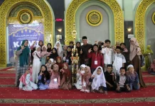 Tim SD Muhammadiyah 15 Surabaya (SDM Limas) pose bersama saat menerima piala juara umum ke 1 di event kompetisi anak islami (KAMI).