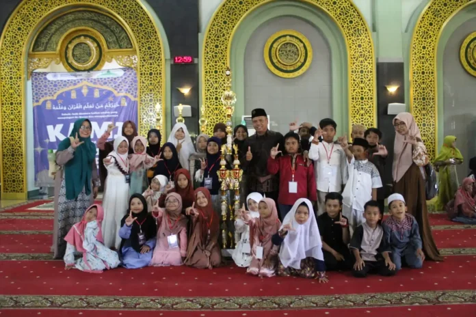 Tim SD Muhammadiyah 15 Surabaya (SDM Limas) pose bersama saat menerima piala juara umum ke 1 di event kompetisi anak islami (KAMI).