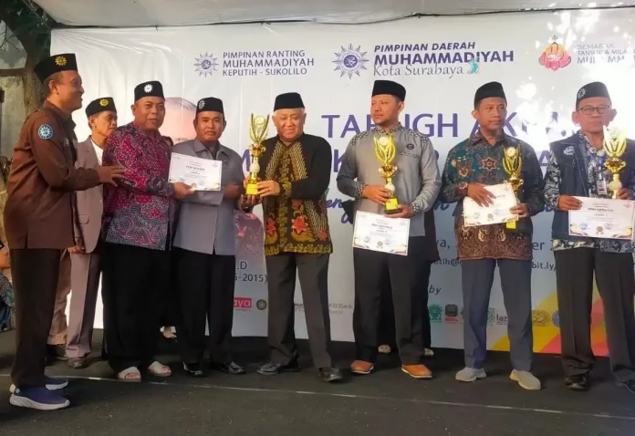 Mantan Ketua Umum PP Muhammadiyah 2005-2015, Din Syamsuddin didampingi Dr Ridwan MPd Ketua Umum PDM Surabaya Memberikan Piala Juara 1 CRM Award 2024 PDM Surabaya kepada Ketua PCM Wiyung.