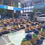 Suasana Kepanduan Hizbul Wathan (HW) SD Muhammadiyah 15 Surabaya (SDM Limas) Bikin Menara Kaki Tiga bersama Ramanda Dody Poernomo SPSI dan Yogi Prasetyo SPd di halaman Sekolah (Ali/PWMU.CO)