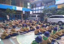 Suasana Kepanduan Hizbul Wathan (HW) SD Muhammadiyah 15 Surabaya (SDM Limas) Bikin Menara Kaki Tiga bersama Ramanda Dody Poernomo SPSI dan Yogi Prasetyo SPd di halaman Sekolah (Ali/PWMU.CO)