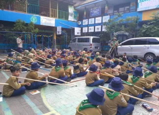 Suasana Kepanduan Hizbul Wathan (HW) SD Muhammadiyah 15 Surabaya (SDM Limas) Bikin Menara Kaki Tiga bersama Ramanda Dody Poernomo SPSI dan Yogi Prasetyo SPd di halaman Sekolah (Ali/PWMU.CO)