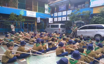 Suasana Kepanduan Hizbul Wathan (HW) SD Muhammadiyah 15 Surabaya (SDM Limas) Bikin Menara Kaki Tiga bersama Ramanda Dody Poernomo SPSI dan Yogi Prasetyo SPd di halaman Sekolah (Ali/PWMU.CO)