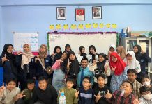 Mahasiswa Poltekkes Kemenkes Surabaya foto bersama siswa usai memberikan penyuluhan di ruang kelas 5 KH Ahmad Dahlan SD Muhammadiyah 15 Surabaya. (Ali/KLIKMU.CO)