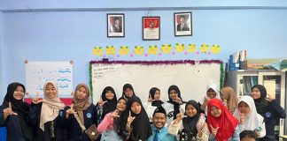 Mahasiswa Poltekkes Kemenkes Surabaya foto bersama siswa usai memberikan penyuluhan di ruang kelas 5 KH Ahmad Dahlan SD Muhammadiyah 15 Surabaya. (Ali/KLIKMU.CO)