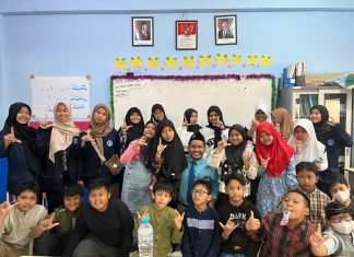 Mahasiswa Poltekkes Kemenkes Surabaya foto bersama siswa usai memberikan penyuluhan di ruang kelas 5 KH Ahmad Dahlan SD Muhammadiyah 15 Surabaya. (Ali/KLIKMU.CO)