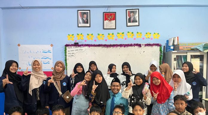 Mahasiswa Poltekkes Kemenkes Surabaya foto bersama siswa usai memberikan penyuluhan di ruang kelas 5 KH Ahmad Dahlan SD Muhammadiyah 15 Surabaya. (Ali/KLIKMU.CO)