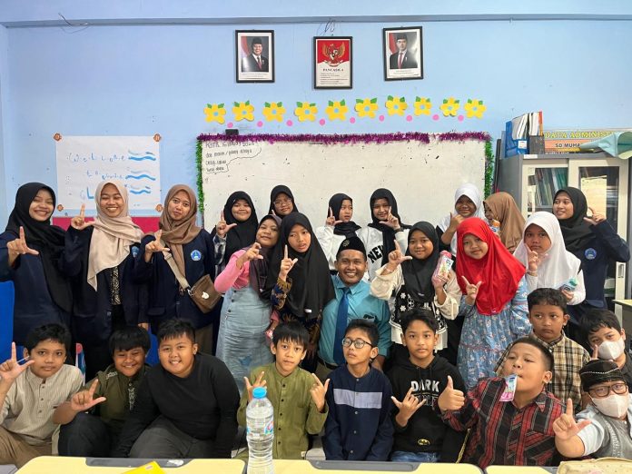 Mahasiswa Poltekkes Kemenkes Surabaya foto bersama siswa usai memberikan penyuluhan di ruang kelas 5 KH Ahmad Dahlan SD Muhammadiyah 15 Surabaya. (Ali/KLIKMU.CO)