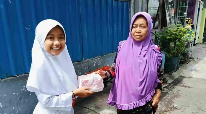 Salah Satu Peserta Jumat Berkah Khairani Gustafunnisa Murid Kelas 5 SDM Limas dengan Tersenyum Saat Berbagi Jum'at Berkah ke Warga Masyarakat Sekitar Sekolah.