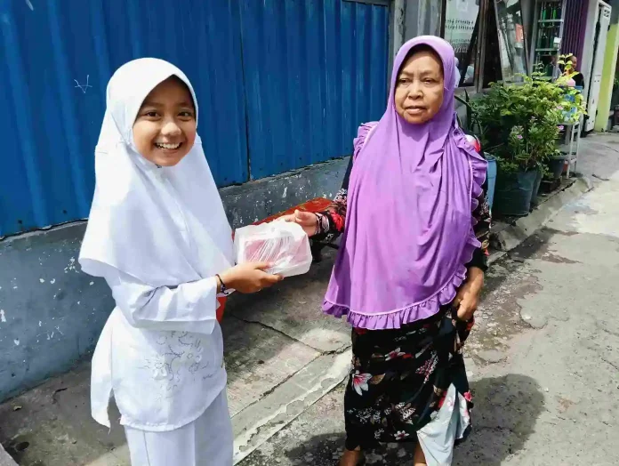 Salah Satu Peserta Jumat Berkah Khairani Gustafunnisa Murid Kelas 5 SDM Limas dengan Tersenyum Saat Berbagi Jum'at Berkah ke Warga Masyarakat Sekitar Sekolah.