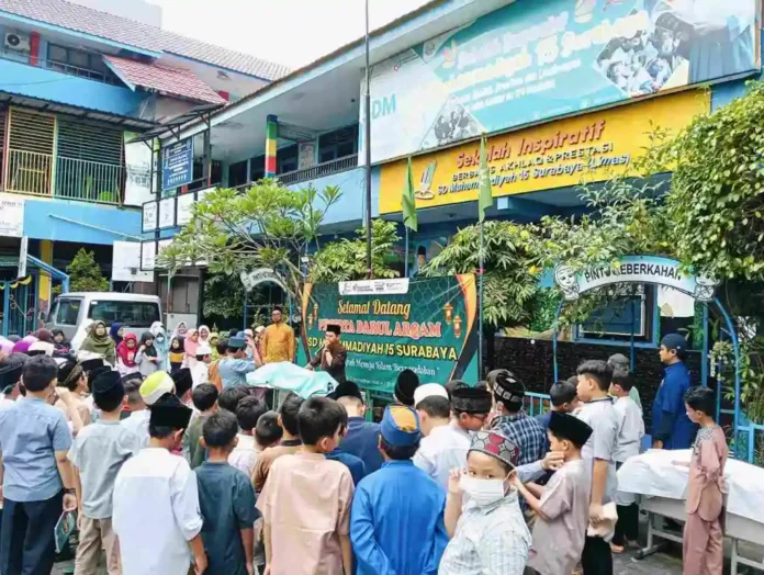 Suasana Peserta Darul Arqam SDM Limas saat simulasi praktik memandikan jenazah di halaman sekolah.
