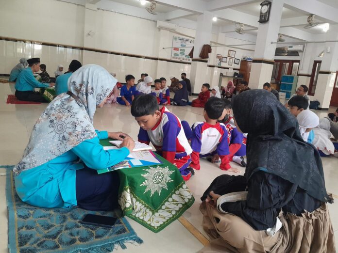 f04e282b-3292-4dd0-8f16-7d4712ba2a99-scaled-e1747326246663 Suasana munaqosah kenaikan jilid Tilawati SD Muhammadiyah 15 Surabaya (SDM Limas) di Masjid At-Taqwa SDM Limas. (Ali/KLIKMU.CO)